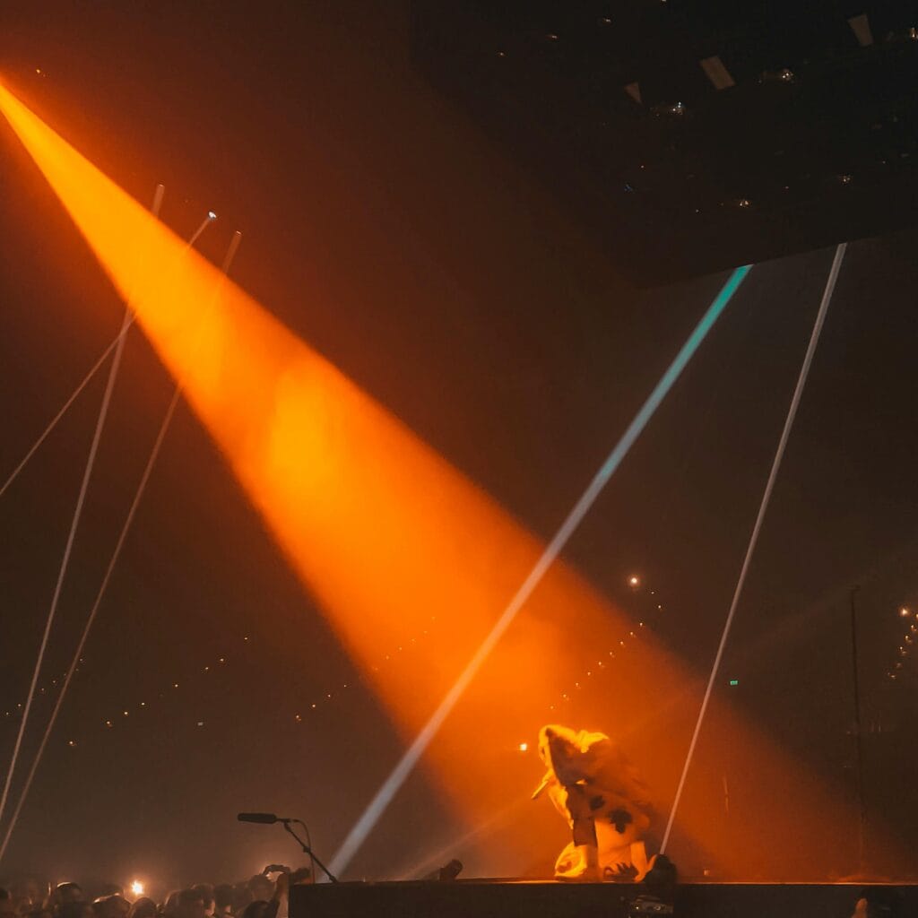 Nosotros 2 Artist on stage with vibrant orange lights during a live concert in Hindmarsh, Australia.